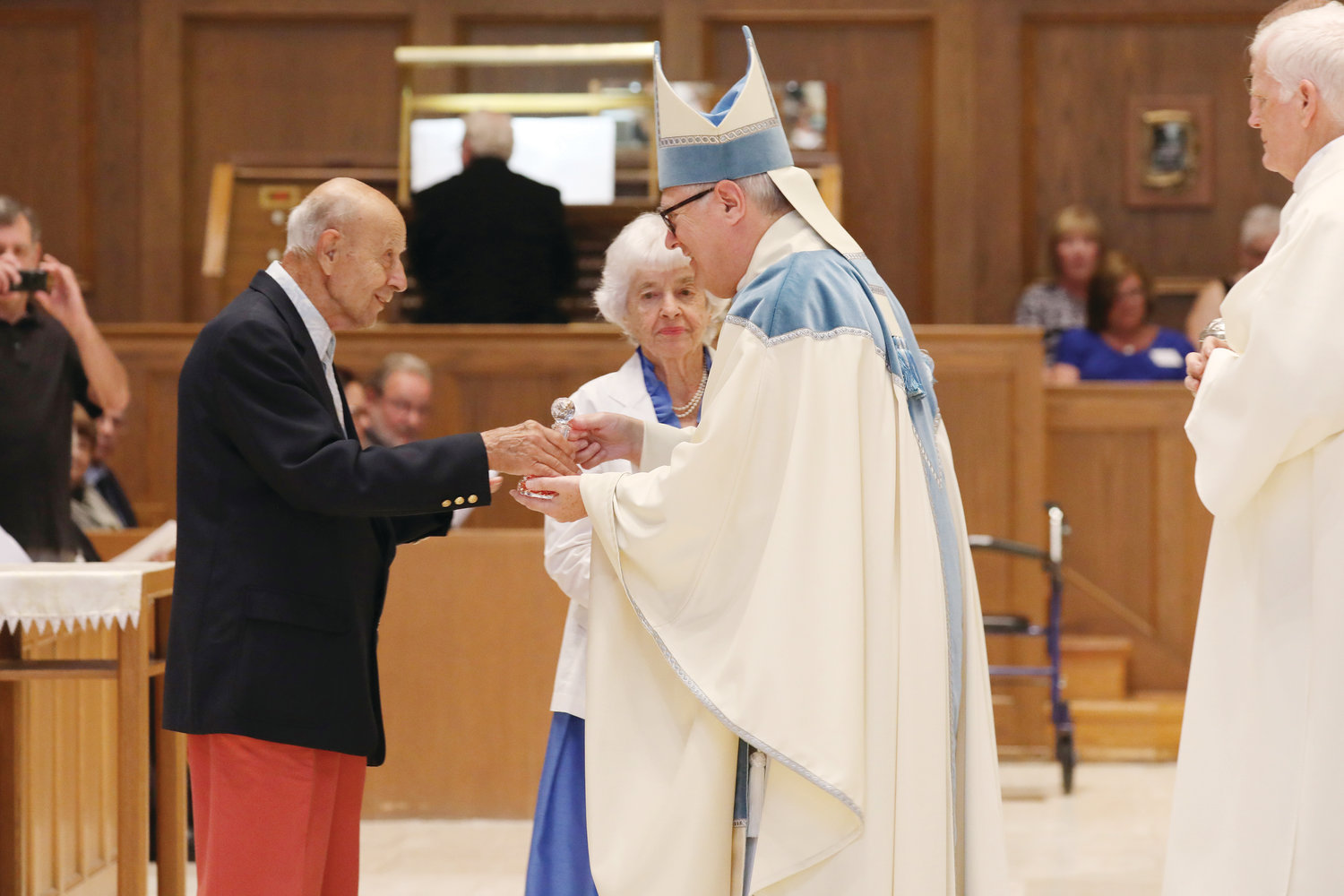 Celebrating 72 years of marriage, Hugo and Serafina Deascentis of Jesus Saviour Parish, Newport, present the gifts to Bishop Thomas J. Tobin.